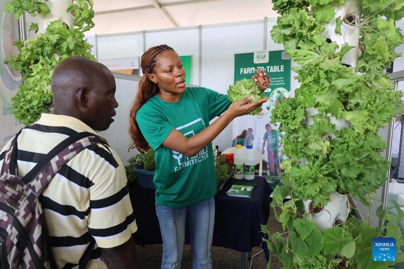 Mwonyeshaji bidhaa (kulia) akimwelezea mtembeleaji kuhusu bidhaa kwenye maonyesho ya sayansi na teknolojia ya kilimo, Accra, Ghana, Machi 17, 2026. (Xinhua/Seth)